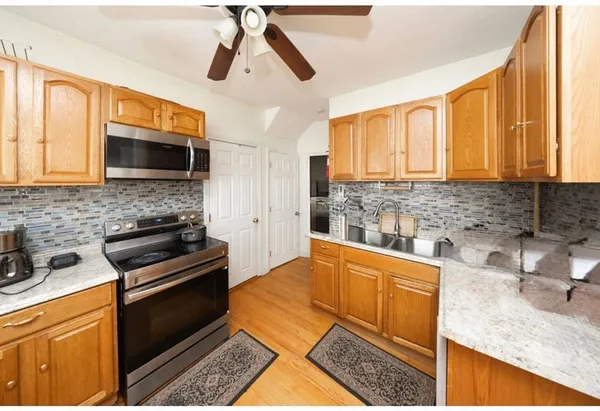 a kitchen with granite countertop a sink a counter top space appliances and cabinets