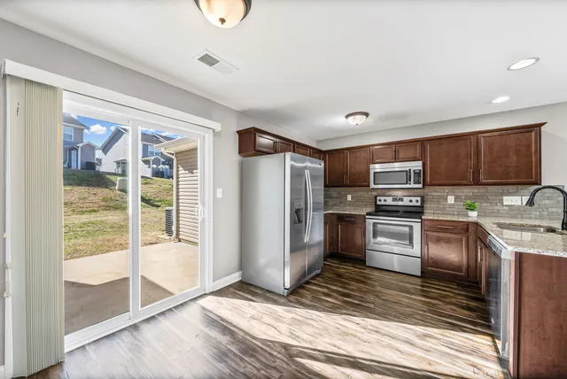 a kitchen with granite countertop a refrigerator and a sink