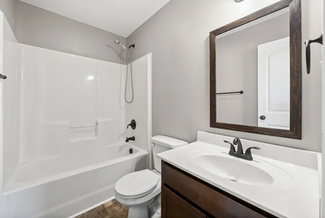 a bathroom with a sink toilet vanity and shower