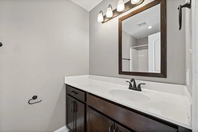 a bathroom with a sink vanity and a mirror