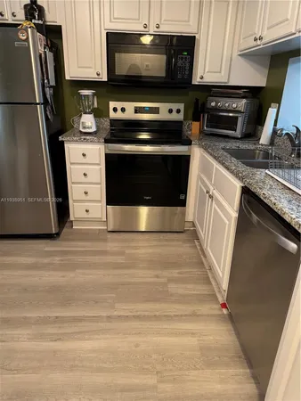 a view of a hallway with wooden floor and chandelier