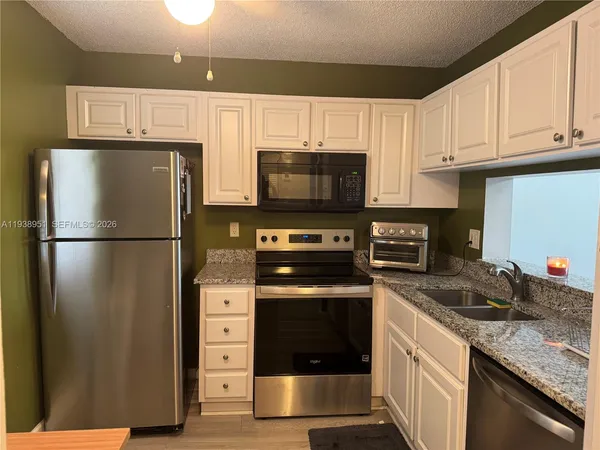 a living room with couch chandelier and a window