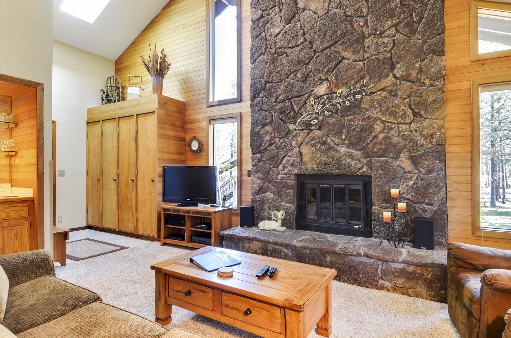 57301 Beaver Ridge Loop, Unit 10 Sunriver, OR 97707 - Photo 3 of 23 a living room with furniture a fireplace and a large window