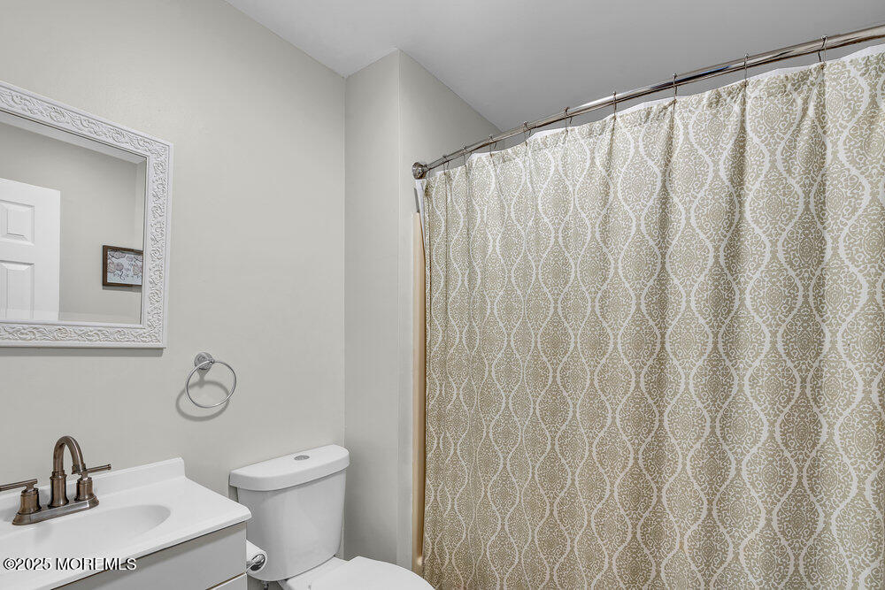 62 Sherman Avenue, Unit A1 Seaside Heights, NJ 08751 - Photo 13 of 17 a bathroom with a toilet a sink and curtain