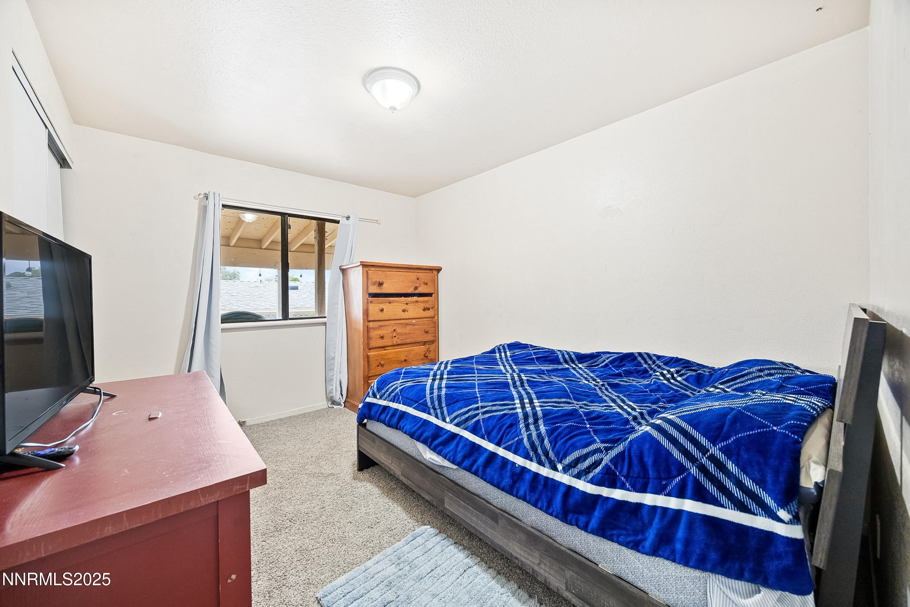 2735 Daffodil Way Reno, NV 89512 - Photo 22 of 23 a bedroom with a bed and a flat screen tv
