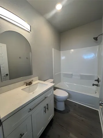 a bathroom with a granite countertop toilet a sink and bathtub