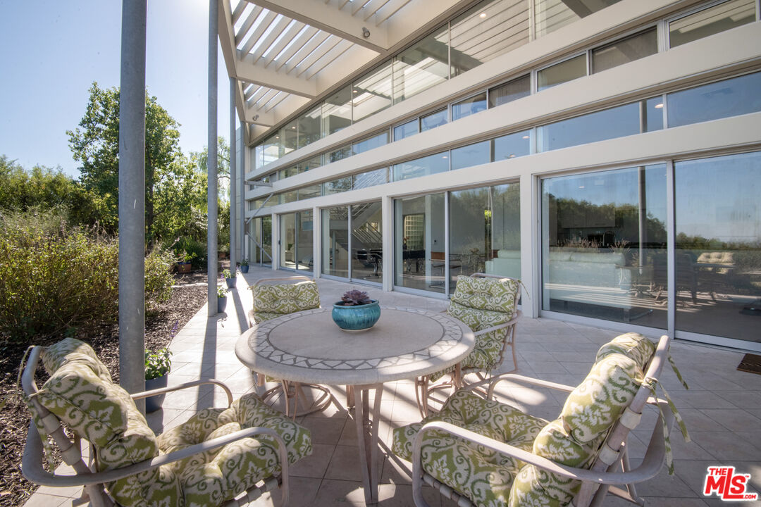 21839 Saddle Peak Road Topanga, CA 90290 - Photo 17 of 72 a view of a patio with table and chairs and potted plants