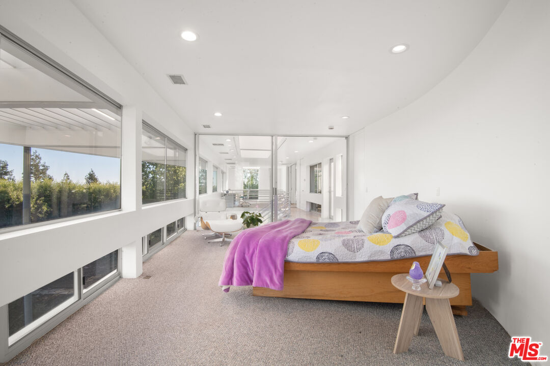 21839 Saddle Peak Road Topanga, CA 90290 - Photo 23 of 72 a spacious bedroom with a bed and a large window