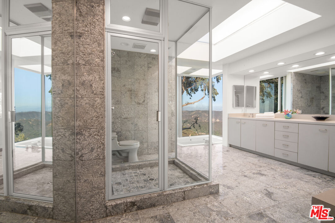 21839 Saddle Peak Road Topanga, CA 90290 - Photo 26 of 72 a bathroom with a glass shower door and a sink