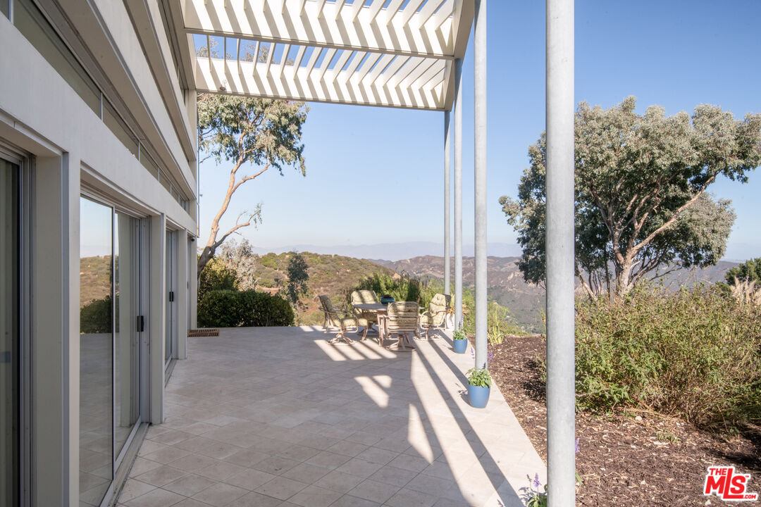21839 Saddle Peak Road Topanga, CA 90290 - Photo 57 of 72 a view of a porch with a table and chairs