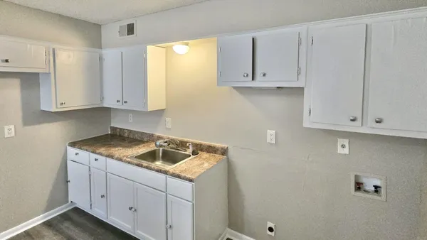 a kitchen with white cabinets and a sink