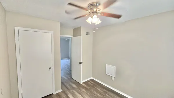 a view of a hallway with a chandelier fan