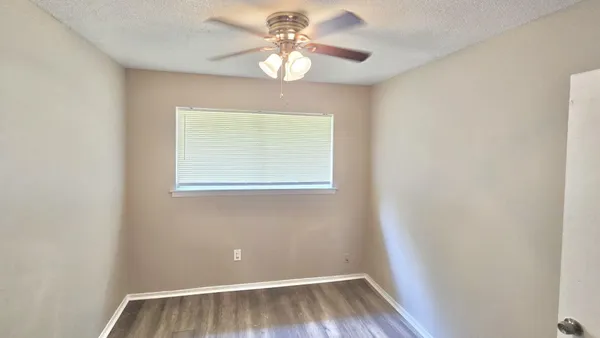 a view of a room with a window and wooden floor