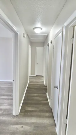a view of a hallway with wooden floor and staircase