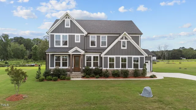 a front view of a house with a yard and trees