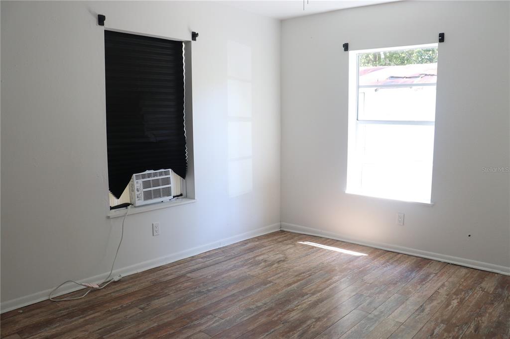 19791 Southwest 108th Lane Dunnellon, FL 34432 - Photo 8 of 19 an empty room with wooden floor cabinet and mirror
