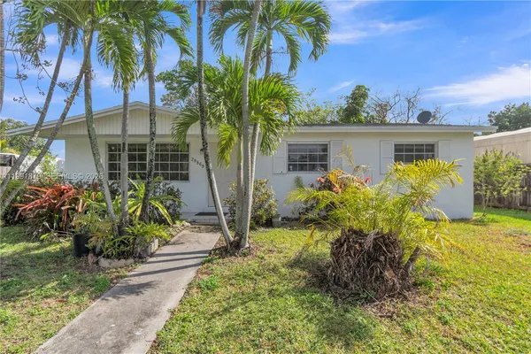 front view of house with a yard and potted plants