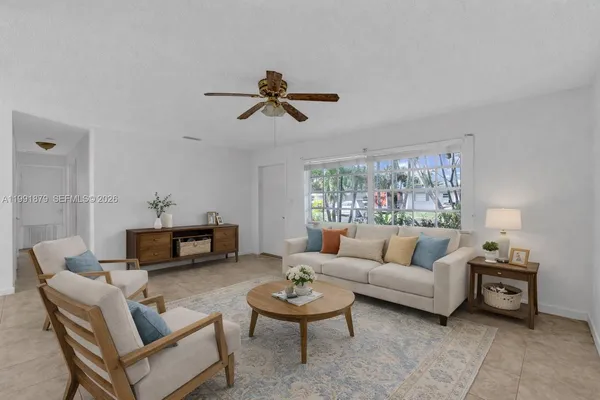 a living room with furniture a ceiling fan and a window