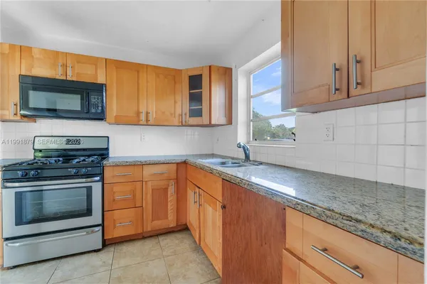 a kitchen with stainless steel appliances granite countertop a sink stove and microwave