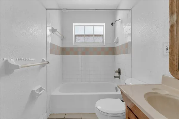 a view of a backyard with plants and a large tree