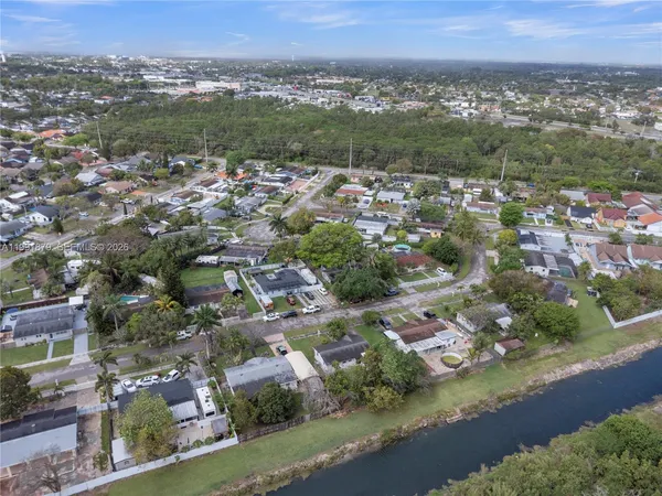 an aerial view of residential houses with outdoor space and trees