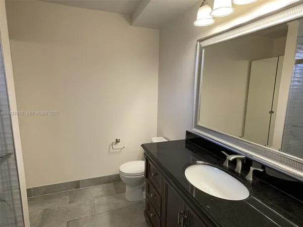 a bathroom with a granite countertop sink and a mirror