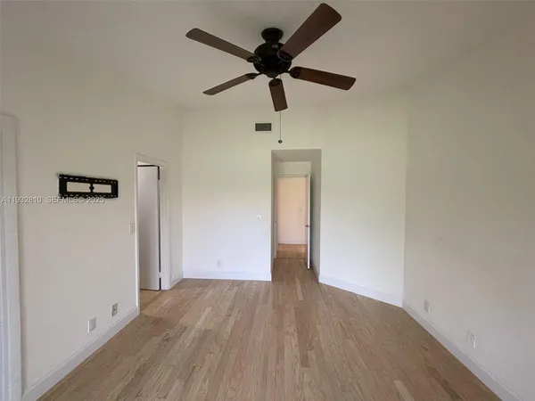 a view of empty room with wooden floor