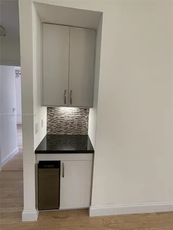 a kitchen with granite countertop white cabinets and black appliances