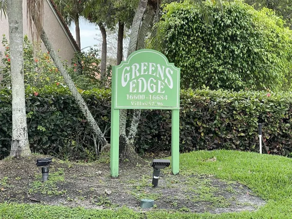 a sign board with a garden