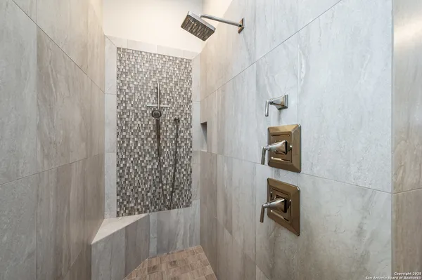 a spacious bathroom with a granite countertop sink a mirror and a shower