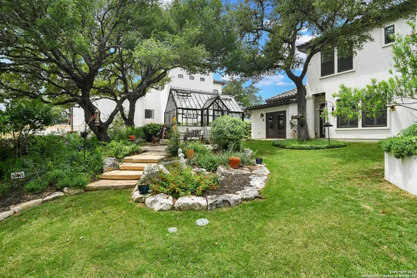 a front view of a house with a yard and potted plants