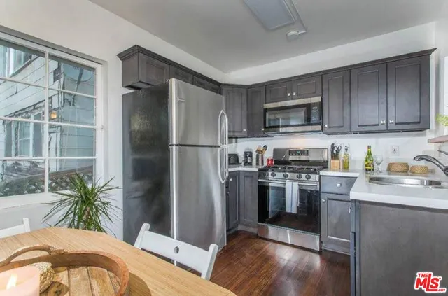 a kitchen with kitchen island a counter top space a sink and stainless steel appliances
