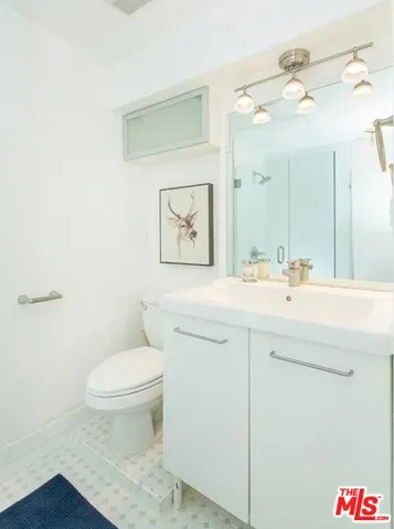 a bathroom with a sink a toilet and mirror