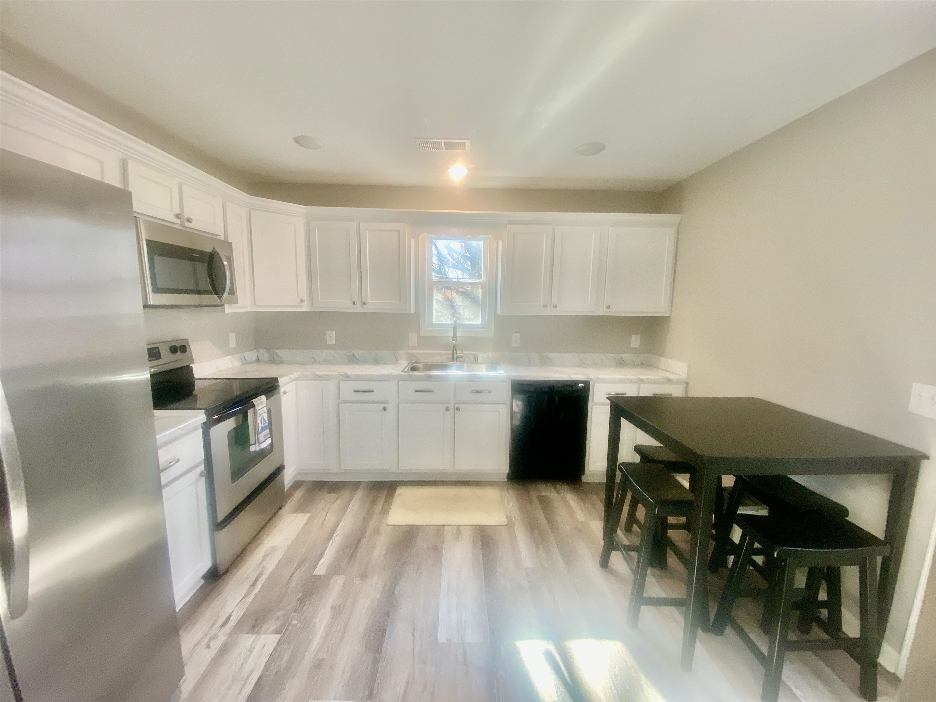 465 Post Office Road Michie, TN 38357 - Photo 5 of 11 Kitchen with sink, stainless steel appliances, laminate floors, and white cabinets