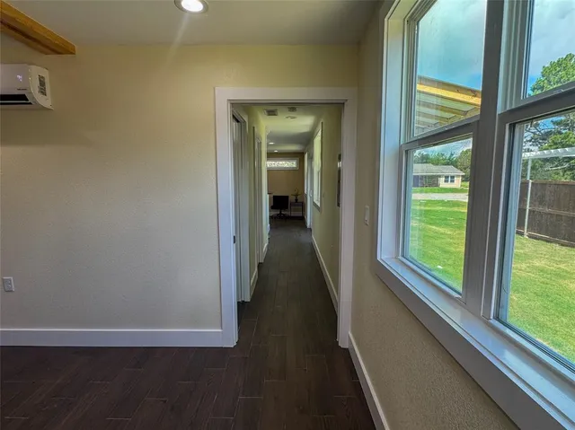 a view of a hallway with wooden floor and a window