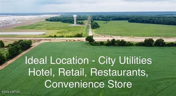 a view of a field with a building in the background