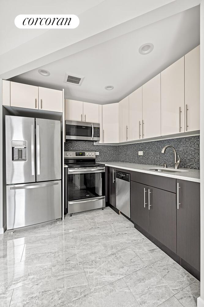 31-10 28th Road, Unit A1 Queens, NY 11102 - Photo 3 of 10 a kitchen with stainless steel appliances granite countertop a refrigerator sink and cabinets