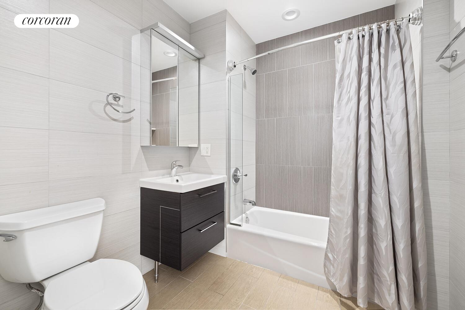 31-10 28th Road, Unit A1 Queens, NY 11102 - Photo 6 of 10 a bathroom with a sink a toilet and a bathtub
