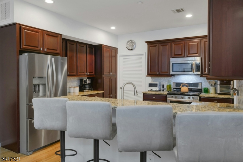 16 Main Street, Unit D6 Sparta, NJ 07871 - Photo 12 of 37 a kitchen with stainless steel appliances granite countertop a refrigerator stove microwave and sink