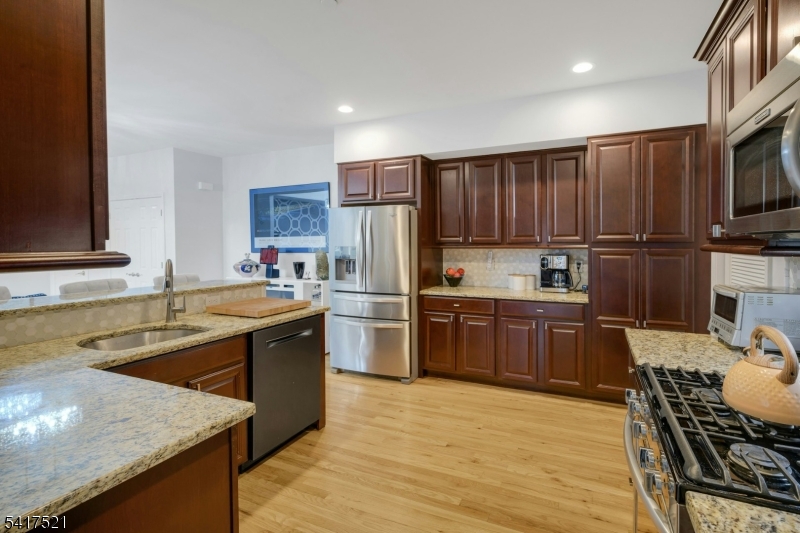 16 Main Street, Unit D6 Sparta, NJ 07871 - Photo 14 of 37 a kitchen with stainless steel appliances granite countertop a refrigerator stove and sink