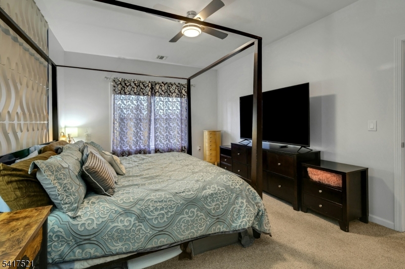 16 Main Street, Unit D6 Sparta, NJ 07871 - Photo 15 of 37 a bedroom with a bed and a flat screen tv