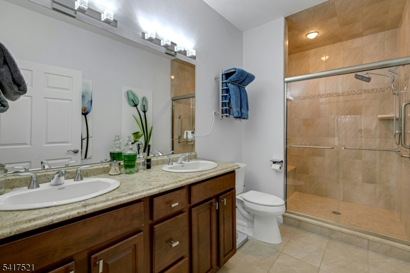 16 Main Street, Unit D6 Sparta, NJ 07871 - Photo 17 of 37 a bathroom with a granite countertop sink toilet and shower