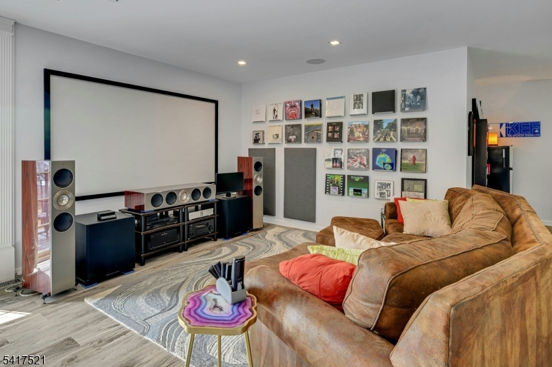 16 Main Street, Unit D6 Sparta, NJ 07871 - Photo 24 of 37 a bedroom with a bed a bookshelf and a flat screen tv