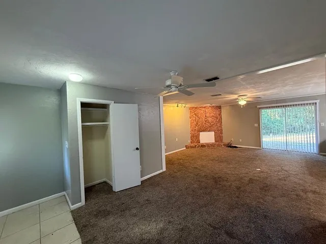 an empty room with windows and a ceiling fan