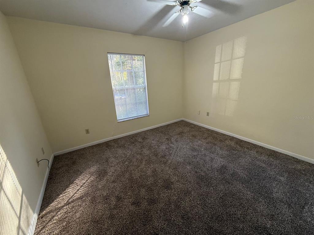 1100 Southwest 20 Place Gainesville, FL 32601 - Photo 18 of 20 an empty room with a ceiling fan and window