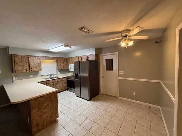 a kitchen with stainless steel appliances kitchen island granite countertop a refrigerator and a stove top oven
