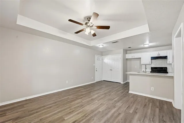 a view of a kitchen with a dishwasher a kitchen island hardwood floor and a ceiling fan