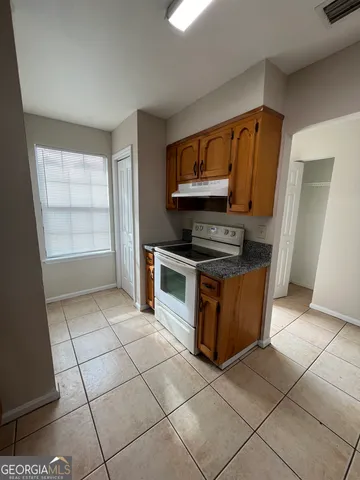a kitchen with stainless steel appliances a stove a microwave and a hard wood floor
