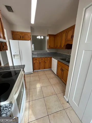 a kitchen with stainless steel appliances a stove a sink and a refrigerator
