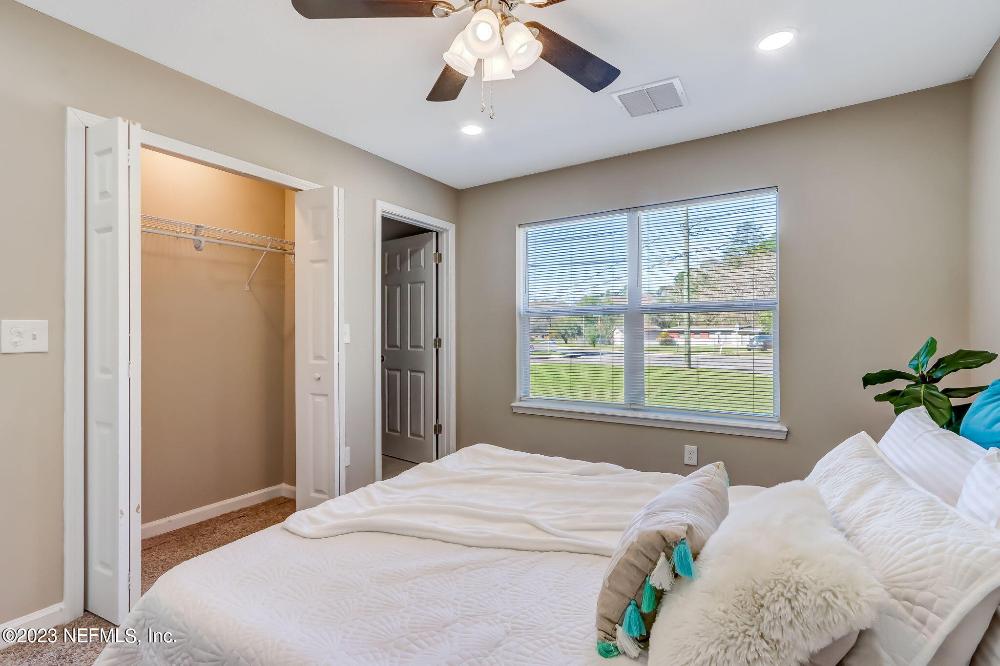 8545 Laurens Road Jacksonville, FL 32208 - Photo 18 of 29 a bedroom with a large bed and a chandelier